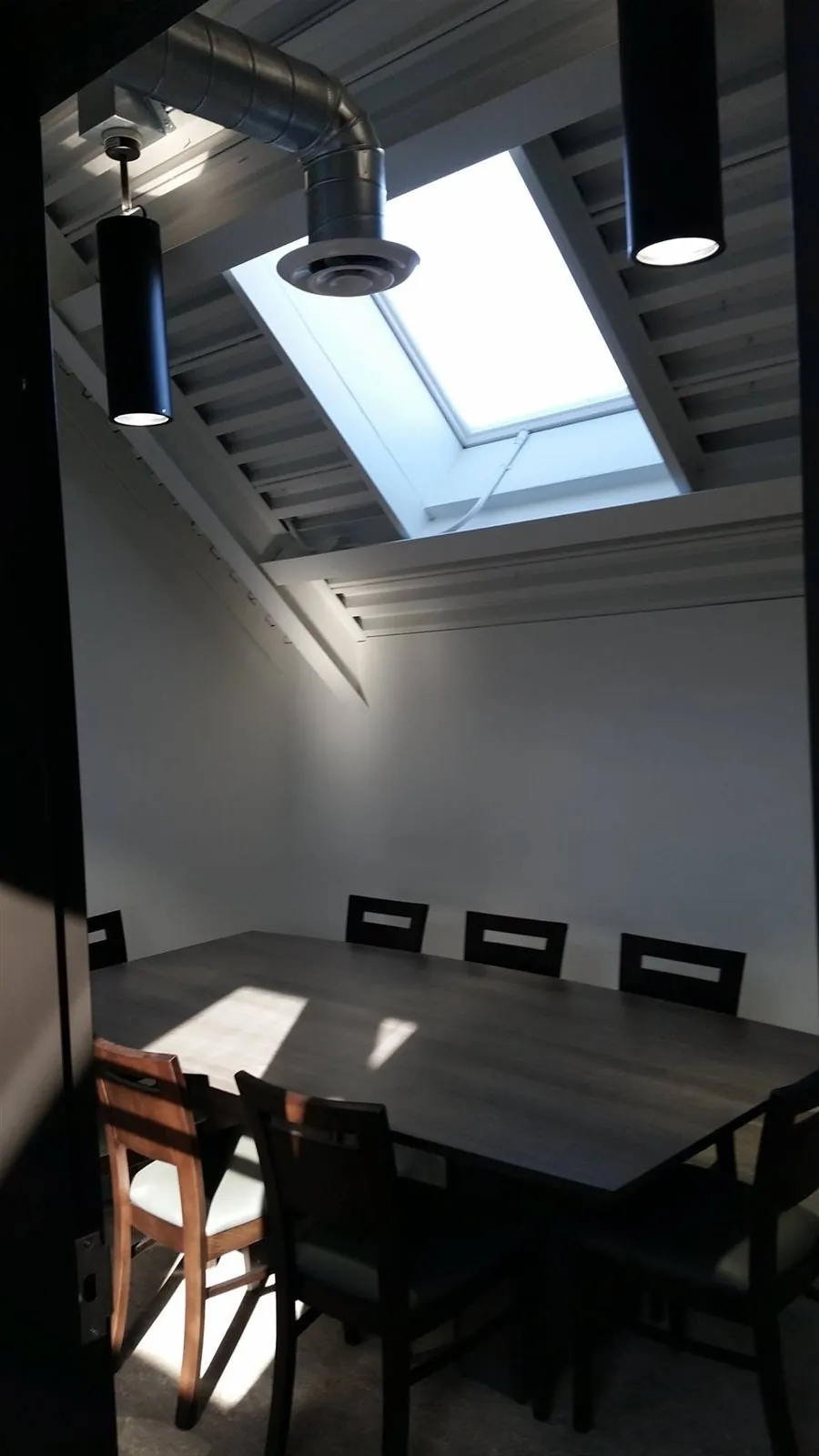 White ceilings and dark accents — Skylit meeting area